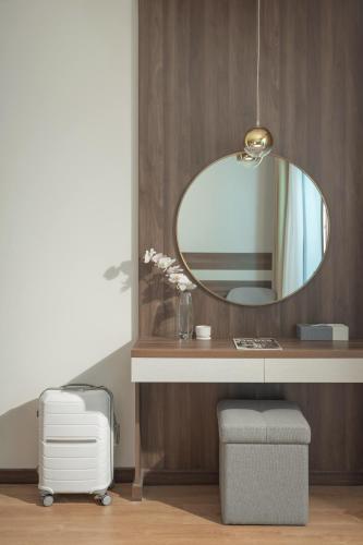a bathroom with a mirror on a wooden wall at PANAMA Nha Trang Hotel in Nha Trang