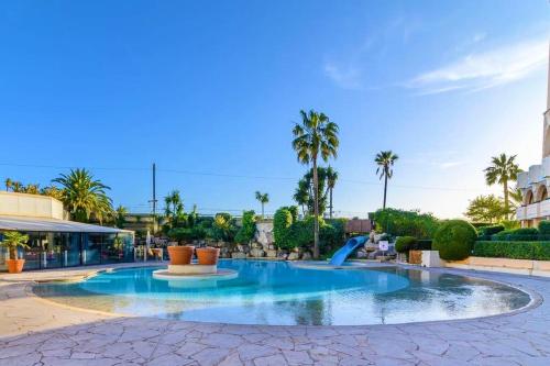 - une piscine dans un complexe avec des palmiers dans l'établissement Appartement Bord de Mer 4 pers / 2 Piscines, à Cannes