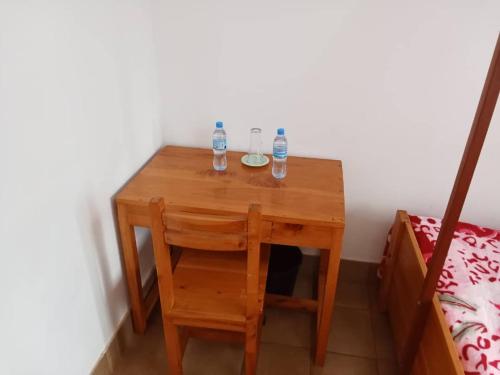 a small wooden table with two bottles of water on it at STC.SAFARI LODGE in Oldeani