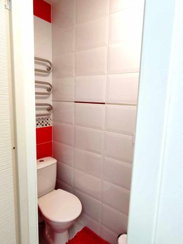 ein kleines Bad mit WC und roten und weißen Fliesen in der Unterkunft Sea Of Nida 2 in Nida