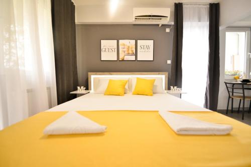 een slaapkamer met een groot geel bed met gele kussens bij Reina Apartments Skopje in Skopje
