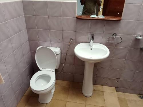 a bathroom with a toilet and a sink at STC.SAFARI LODGE in Oldeani