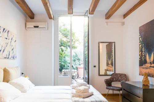 a bedroom with a bed and a chair and a window at Palm Fronds in Milan