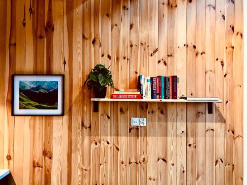 a wooden wall with a shelf with books on it at Przyjedź Tutaj in Maków Mazowiecki