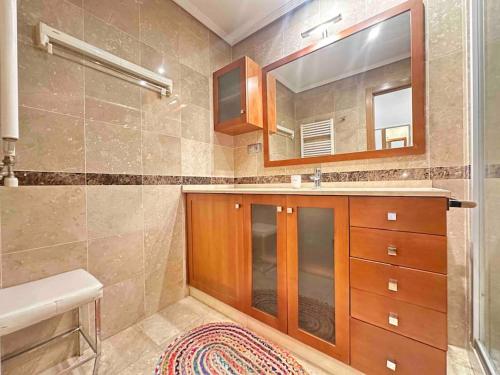 ein Bad mit einem Waschbecken, einem Spiegel und einer Dusche in der Unterkunft Luxury Centro de Vigo Balcony in Vigo