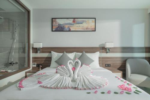 a bedroom with a white bed with flowers on it at PANAMA Nha Trang Hotel in Nha Trang
