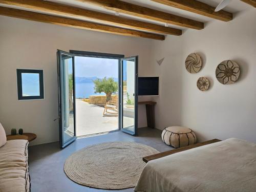 a bedroom with a bed and a large glass door at Lefki Sokolata in Koufonisia