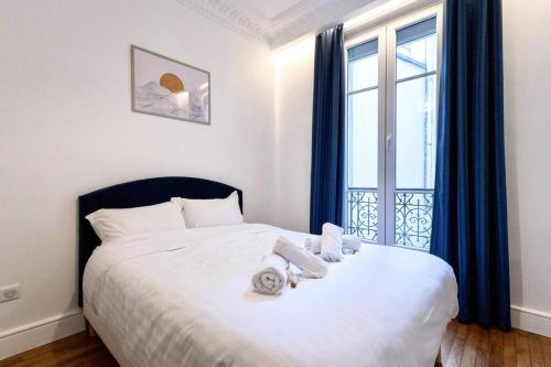 une chambre avec un lit avec des serviettes dessus dans l'établissement Magnifique Appartement 6P - Auteuil/Michel Ange, à Paris