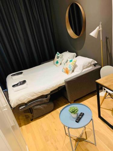 Cette chambre comprend un lit avec une table et un miroir. dans l'établissement Le Petit Lyonnais - Coeur de Lyon - 2 pers., à Lyon