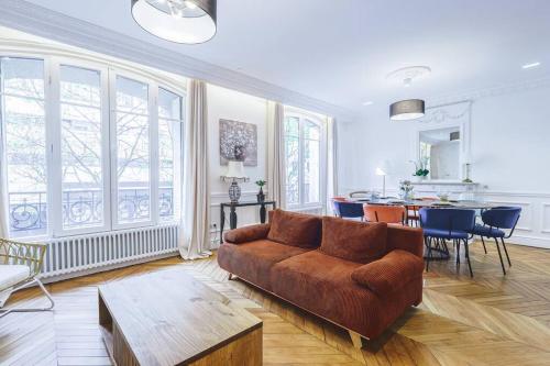 un salon avec un canapé marron et une table dans l'établissement Magnifique Appartement 6P - Auteuil/Michel Ange, à Paris