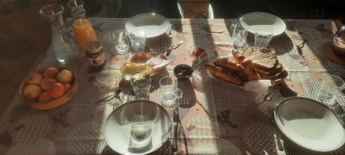 un tavolo con una tovaglia con pane e bicchieri di Chambres d'Hôtes La Bonne Voie a Lembras