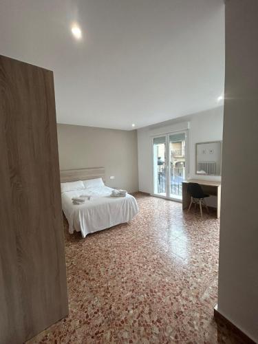 a bedroom with a bed and a desk in it at Pensión Arnedo in Arnedo