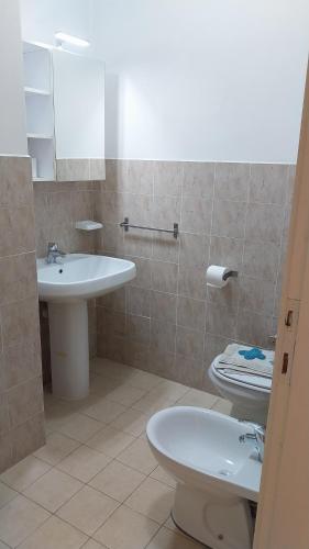 a bathroom with a white sink and a toilet at Appartamenti La Rosa dei Venti in Lacona