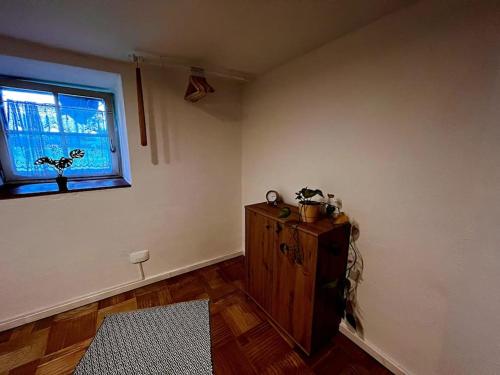 a living room with a window and a wooden cabinet at Genau so - Allgäu! Sau Gemütlich in Maierhöfen