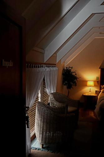 a room with two chairs and a window with curtains at The Leopard Tree in Polokwane