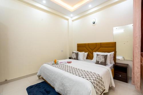a bedroom with a large bed and a mirror at Homlee-Vasundhara 3BHK Flat- kitchen-Parking-Lift in Ghaziabad