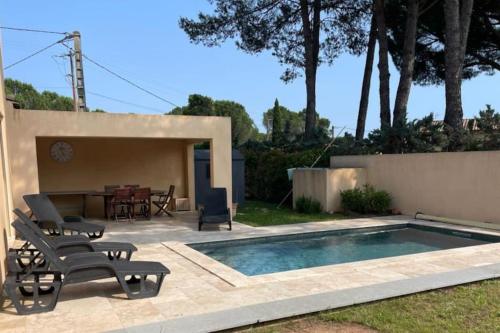 een achtertuin met een zwembad en een tafel en stoelen bij Beautiful Villa with pool! in Vidauban
