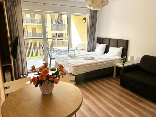 een kamer met een bed en een tafel met een bank bij Natura Resort in Pogorzelica