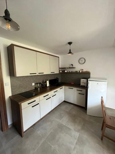 a kitchen with white cabinets and a white refrigerator at Penzion U Křížku in Malá Morávka