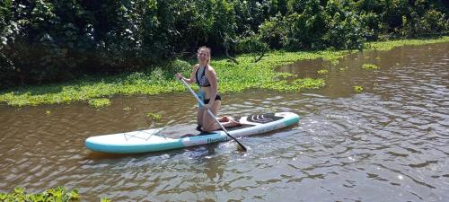 a woman is standing on a paddle board in the water at Bali Villa Mirissa in Mirissa