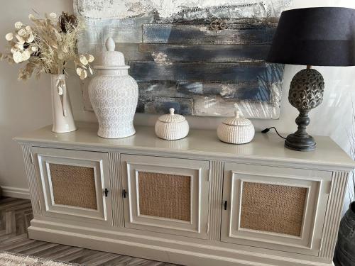 a white console table with a lamp and vases on it at Gorey retreat main house in Gorey