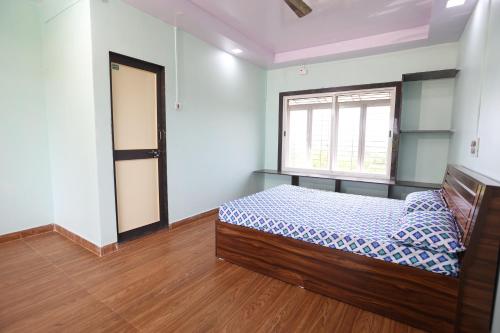 een slaapkamer met een bed en een raam bij Gokarna villa Tondavali in Achra