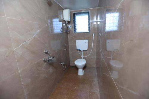 a bathroom with two toilets and a shower at Gokarna villa Tondavali in Achra