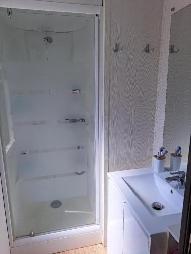 une salle de bain blanche avec une douche et un lavabo dans l'établissement Mobile Home 270, à La Roque-dʼAnthéron