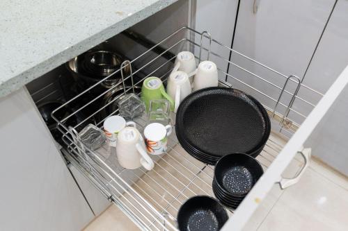 a dish rack with utensils and dishes in a kitchen at Homlee-Vasundhara 3BHK Flat- kitchen-Parking-Lift in Ghaziabad