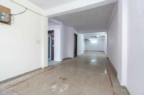 an empty hallway with white walls and concrete floors at Homlee-Vasundhara 3BHK Flat- kitchen-Parking-Lift in Ghaziabad