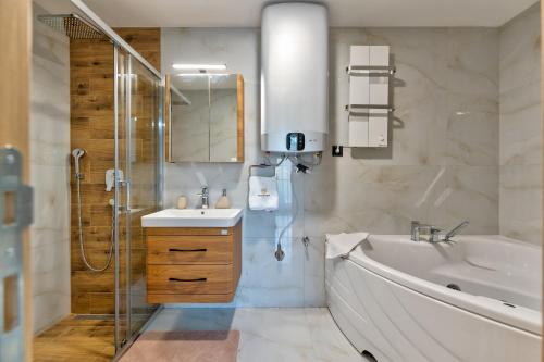 a bathroom with a sink and a tub and a shower at Golden Panorama Spa & Wellness in Zlatibor