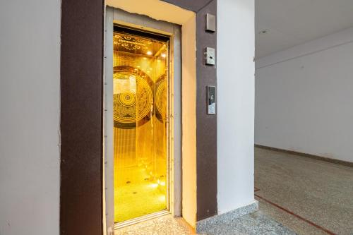 a glass door with a clock in a building at Homlee-Vasundhara 3BHK Flat- kitchen-Parking-Lift in Ghaziabad