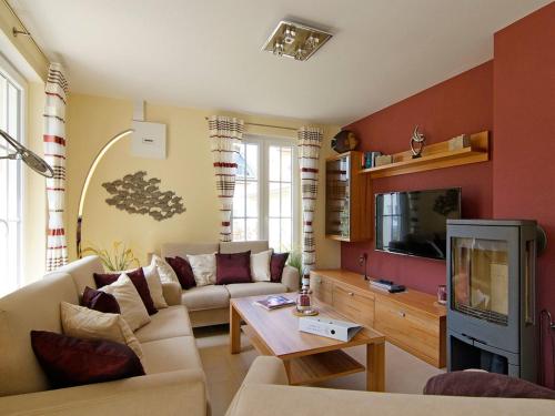 a living room with a couch and a tv at Villa Harmony in Glowe
