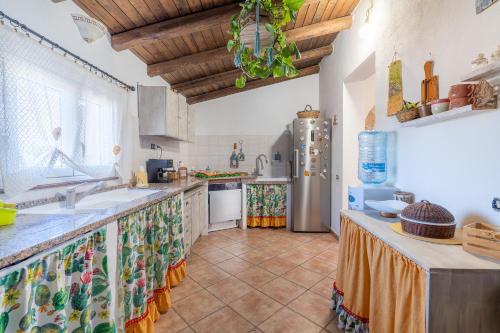 a kitchen with a sink and a refrigerator at Sara Home in Portopalo