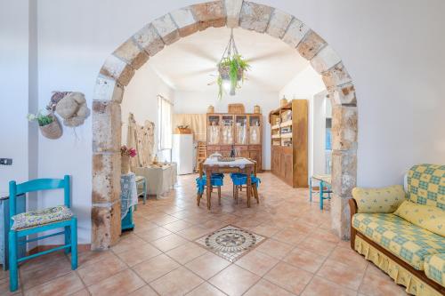a living room with an archway and a table and chairs at Sara Home in Portopalo