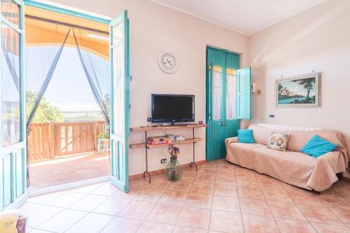 a living room with a couch and a television at Sara Home in Portopalo