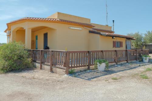 a house with a wooden fence in front of it at Sara Home in Portopalo