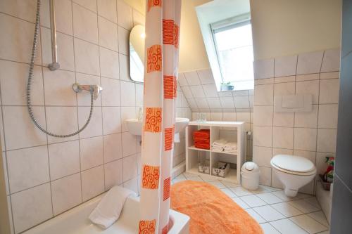 y baño con ducha, aseo y lavamanos. en Ferienwohnungen auf dem Carlshof in Jork - Altes Land, en Jork