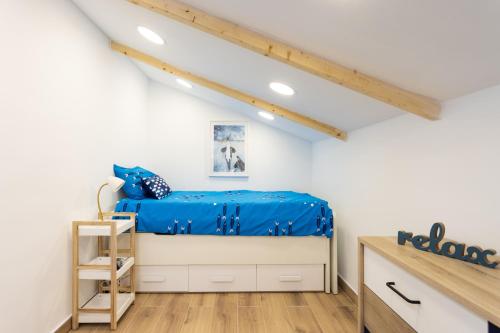 een slaapkamer met een blauw bed op een zolder bij Villa Mencey in San Miguel de Abona