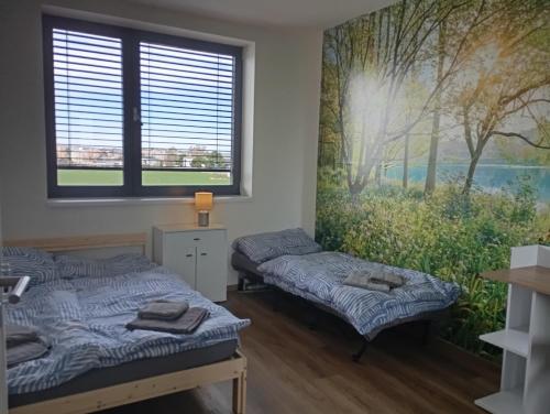 2 Betten in einem Zimmer mit Wandgemälde in der Unterkunft Moderní luxusní sdílený rodinný apartmán 