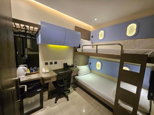 a small room with a desk and bunk beds at Beauty Hotels Taipei - Hotel B7 in Taipei