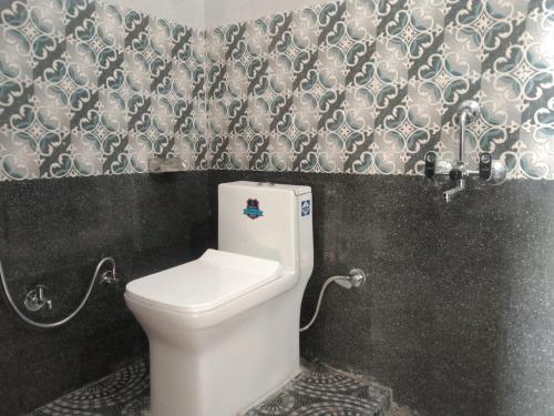 bagno con servizi igienici bianchi in una cabina di Sunrise Home Stay ad Almora