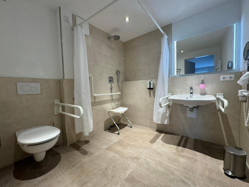 a bathroom with a toilet and a sink at Fontane Hotel in Schorfheide