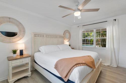 a white bedroom with a bed and a window at Walk to Las OlasThe Seagrape Palm Paradise Inn in Fort Lauderdale