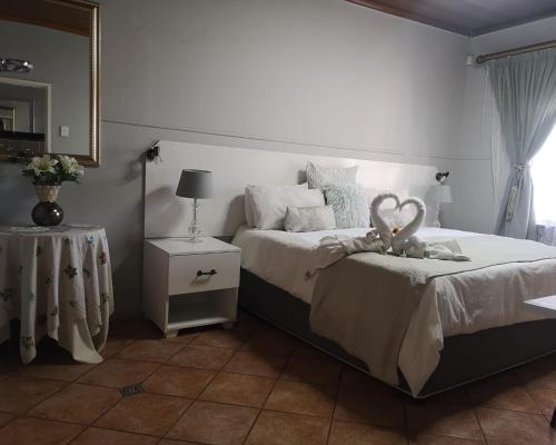 a bedroom with a bed with a teddy bear on it at Elsje's Country Inn in Kempton Park