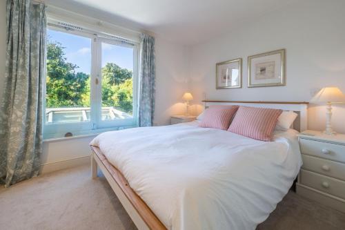 Un dormitorio con una cama grande y una ventana en 207 High Street 4 en Aldeburgh