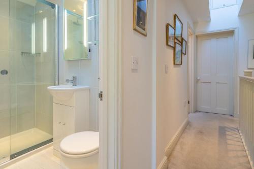 La salle de bains est pourvue de toilettes et d'une douche en verre. dans l'établissement 207 High Street 4, à Aldeburgh