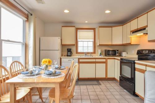 a kitchen with a table and chairs and a kitchen with a refrigerator at Beautiful Views of Cape Cod Bay in Truro