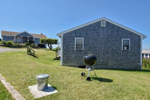 a grill on a stand in front of a house at Beautiful Views of Cape Cod Bay in Truro