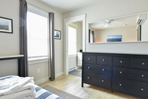 um quarto com uma cómoda e um espelho em Modern, Private Patio, Walk to Town! em Provincetown